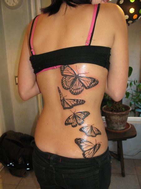 Tattoo of angel wings on middle of upper back.