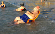 This guy was lounging on a deck chair in the water on the beach in Netanya, . (fat man on beach)