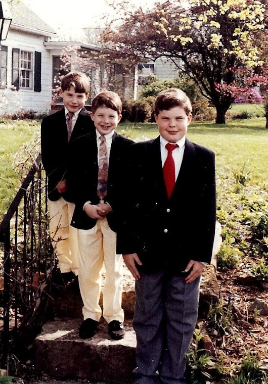The boys pose proudly in front of their house.