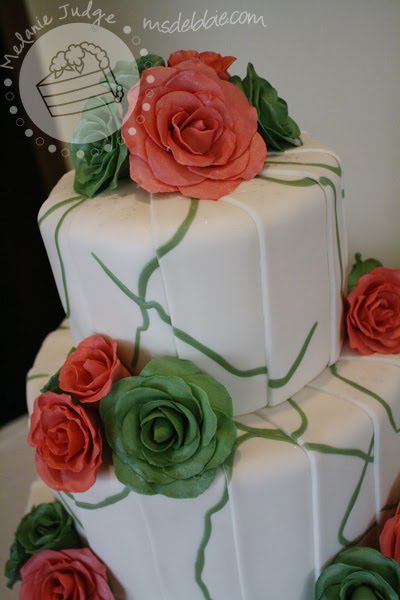 white fondant wedding cake green swirls with green and pink roses