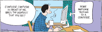 Adam is sitting at his desk talking to the computer. Computer, computer in front of me. Who's the nearest that you see? To which the computer responds Some nutcase talking to a computer.