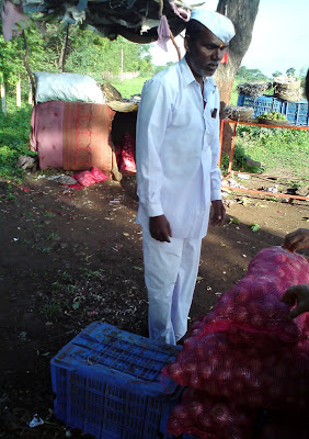 A farmer sells Onions on the Mumbai-Nashik highway