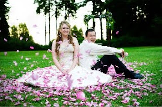 A cute wedding photo with flying rose petals.
