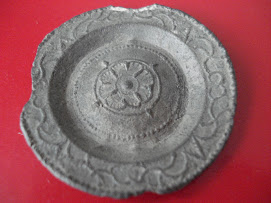 A child's toy plate. Made from pewter and lead. About an inch wide.