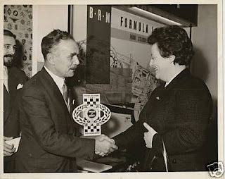 CHRIS SHORROCK RECEIVES A MERIT AWARD FOR THE SHORROCK STAND FROM SHEILA VAN DAMM, RACING CAR SHOW 1961