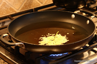 Frying elderflower fritters in a pan