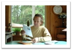 Photo of Bill reading his mail at his kitchen table