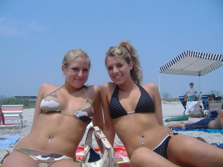 Молодая девушка на фотосессии в бикини на пляже показывает большие дойки
