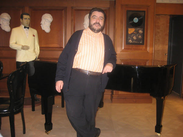 Damián de pie apoyado en el piano con Bogart