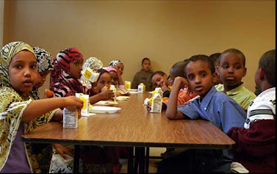Somali elementary students at lunch, girls in headscarves, color photo
