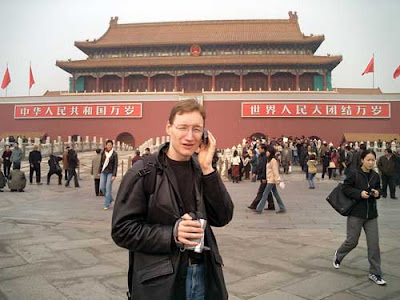 Man talking on a cell phone in the middle of Tianenmen Square