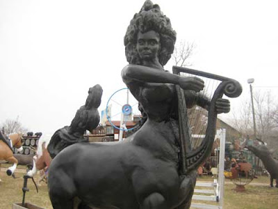 A female centaur with hair piled on her head, holding a harp