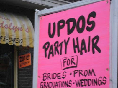 Hand-painted pink sign with black letters reading UPDOS Party Hair