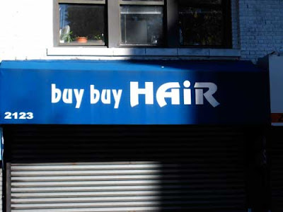 Blue awning with white letters reading Buy Buy Hair