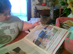 Aqui, en esta foto, leo el periódico con mi humana, es la que aguanta el papel