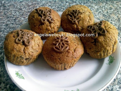 Áfonyás répás muffin, gyömbéres étcsokoládés áfonyás sárgarépás tésztával, csokoládé lapokkal díszítve.