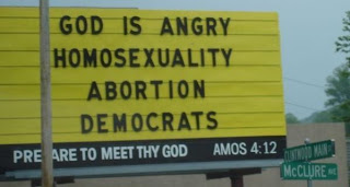 Sign reads, 'GOD IS ANGRY - HOMOSEXUALITY - ABORTION - DEMOCRATS'