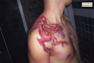 Dragão vermelho tatuado no ombro.