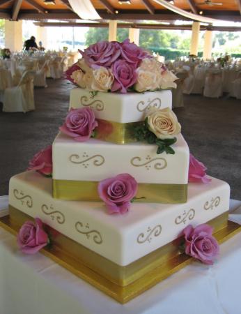 This three tiered off set square wedding cake is covered in ivory fondant 