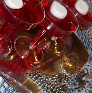 Solidified red Jell-O in glasses each with one marshmallow