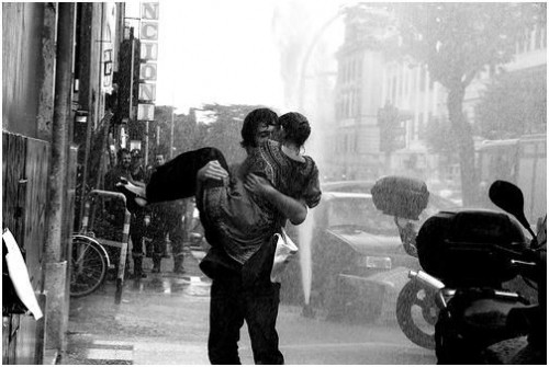 romantic couple kissing in rain. couple kissing in rain. young