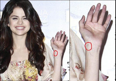 selena gomez has a little cross on her wrist, but it's not a tattoo. just 