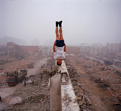 Lei Wei photo, man upside down on the top of a wall in the middle of ruins