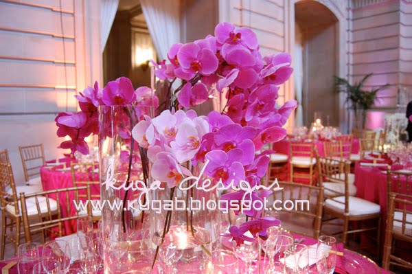 light pink to fuchsia Phalaenopsis orchids surrounded by clear cylinder