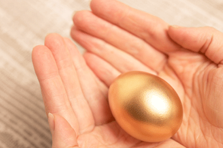 Hands Holding a Golden Egg