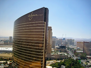 a tall building with a curved top with Encore Las Vegas in the background