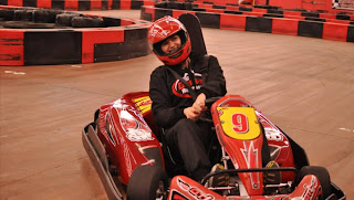 An image of a person driving a red go-kart