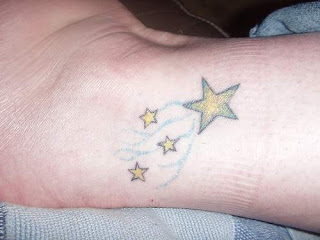 Tatuagem de estrelas com preenchimento amarelo no tornozelo