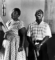 Photo of Ella Fitzgerald and Louis Armstrong singing together, links to CD titled Ella & Louis