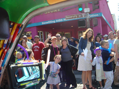 People in a parade waving at the Mercedes Pens