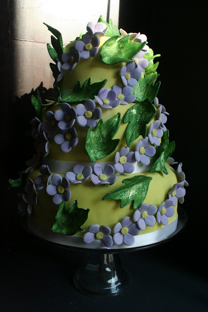 wedding cake was garlanded with mauve violets and green ivy