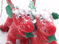 two stuffed red dragons with snow