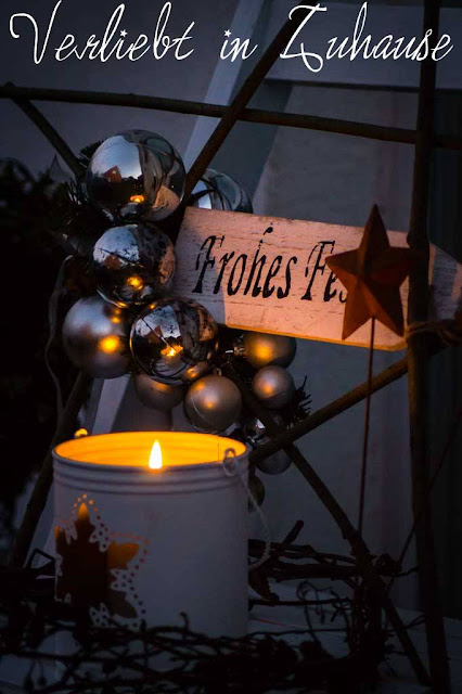Haustüdeko im Winter zu Weihnachten mit selbst gemachten Stern aus Ästern und schönen Lichter Bokeh