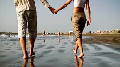 Photos of young couples are holding hands and walking on the beach