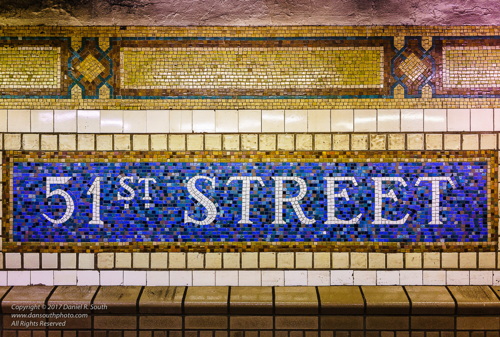 a photo of an elaborate tile sign in the new york subway