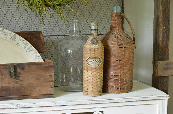 A collection of vintage wicker wine bottles make an interesting display. | www.andersonandgrant.com