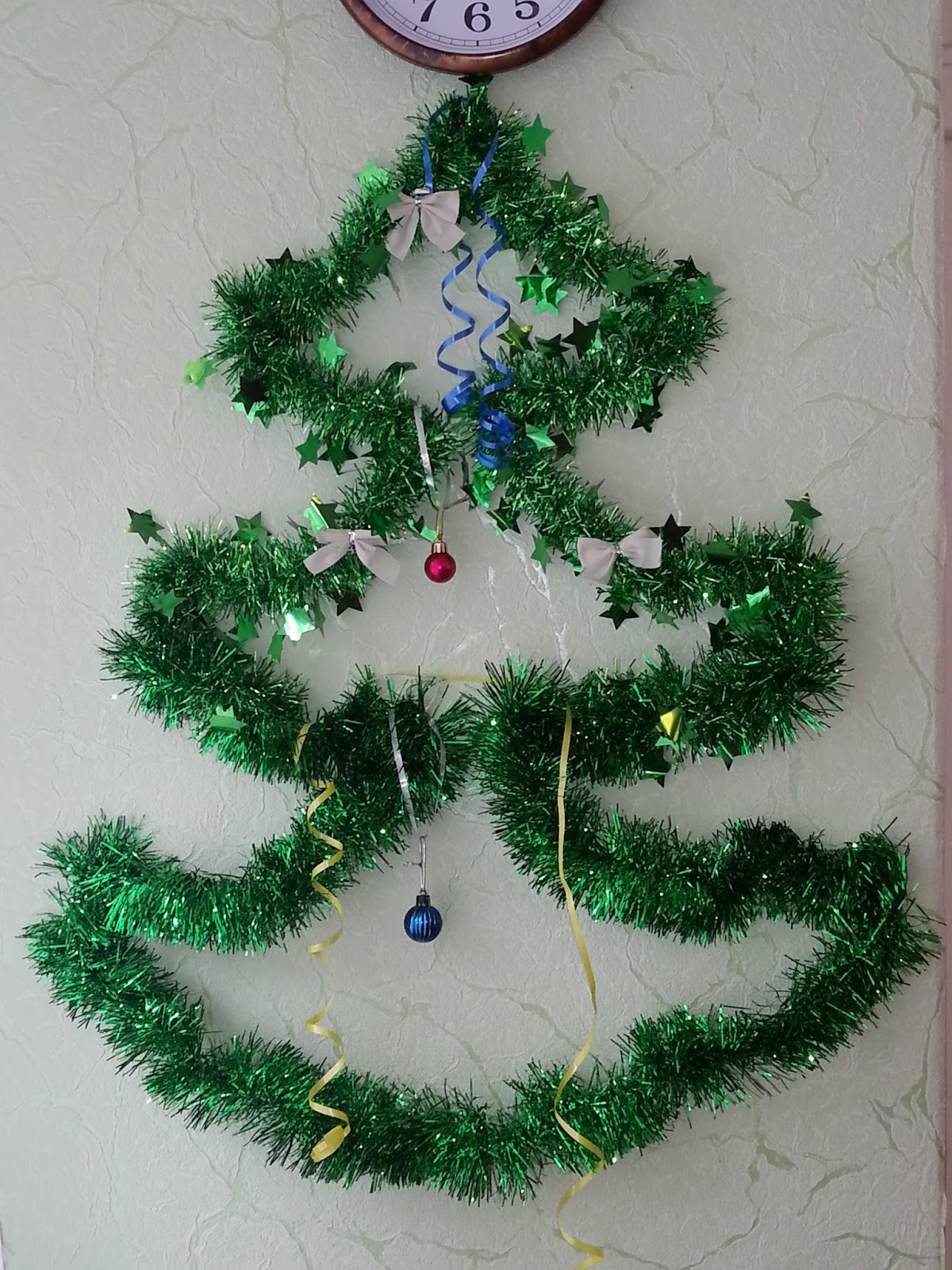 Объемная елка на стену из мишуры. Украшение из мишуры на стену. На дверь елка из дождика. Елочка из мишуры на стене. Как сделать елку из мишуры на дверь.