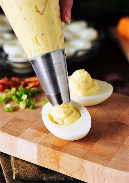 Piping Deviled Egg Filling Image ~ Using a piping bag makes quick work of filling deviled eggs, whether they're classic flavor or these Bacon-Cheddar Deviled Eggs.