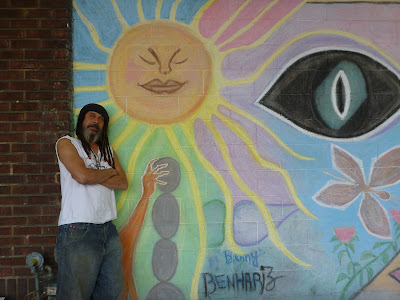 Artist Benny Benhariz Poses in Front of his Mural