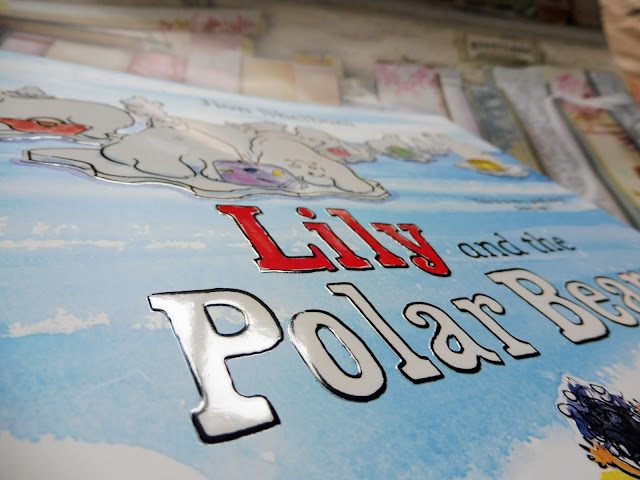 Close up image of the front cover and the book title which reads Lily and The Polar Bears by Jion Sheibani and is written in a raised font surrounded by images of polar bears
