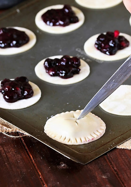 Cutting Slits in the Top of Blueberry Pie Cookies Image