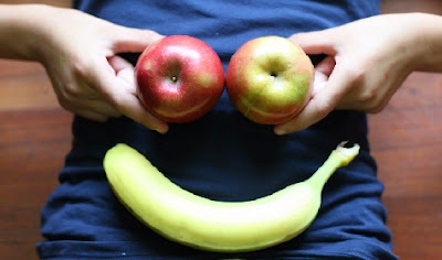 Cara con manzanas y plátano