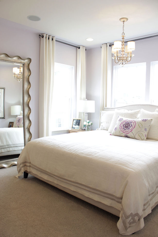 Bright bedroom with soft purple accents and big mirror on the floor