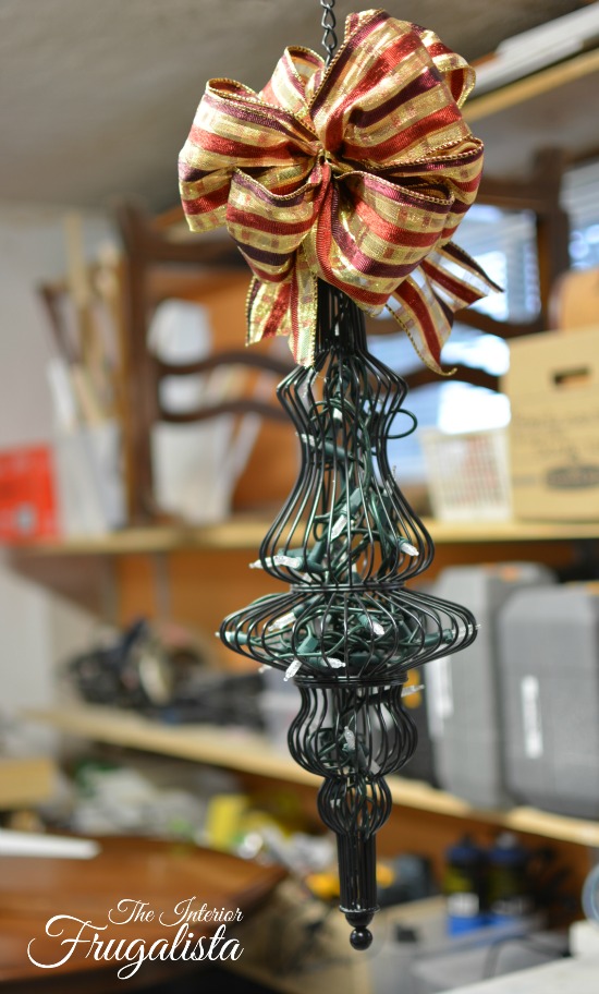 Adding some holiday ribbon to the top of patio candleholders repurposed for the holidays