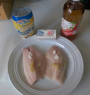 frozen tilapia filets on a plate with butter, garlic and vinegar