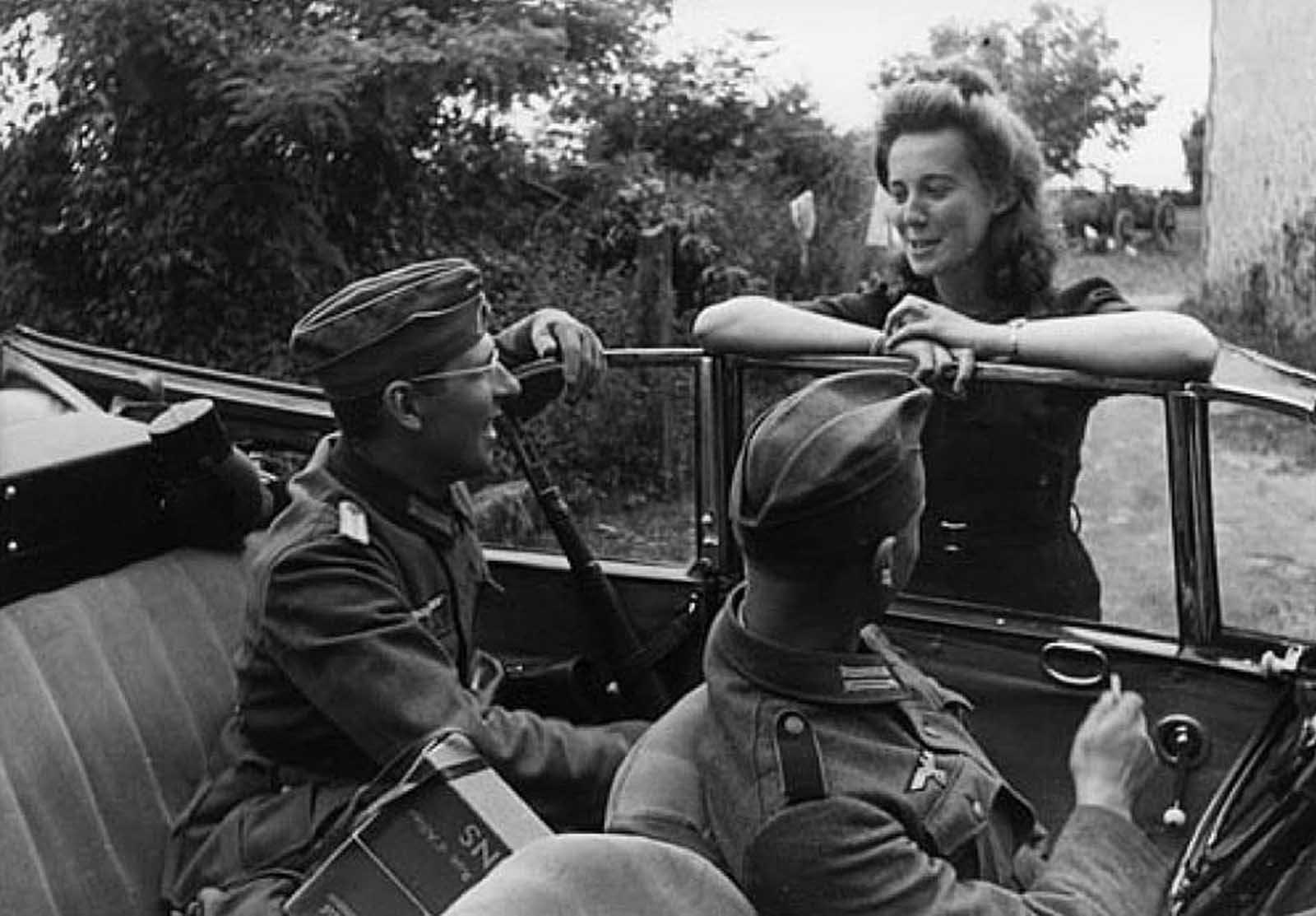 German soldiers and a French girl engage in a conversations 